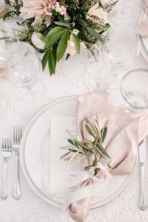 A table set with plates and blush pink napkins