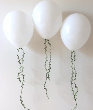 Quinceanera, a bunch of white balloons hanging from a wall