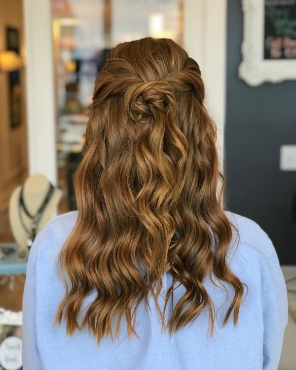 Quinceanera image: The back of a woman's head with long wavy hair styled for the event.