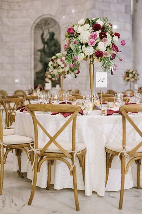 Quinceanera table decorations, a burgundy and blush table with a vase of flowers on top