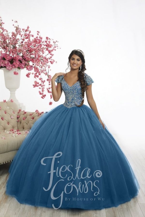 A woman in a blue Quinceanera ball gown posing for a picture