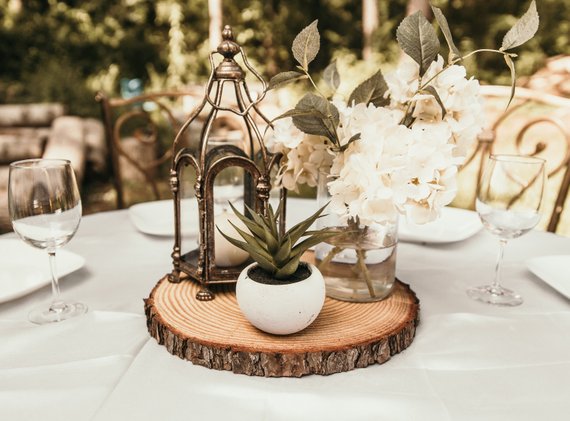 Quinceanera rustic table centerpiece with a vase of flowers and a candle
