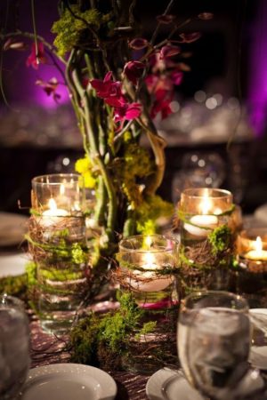 Quinceanera forest centerpieces table set with candles and flowers in a vase