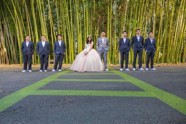 Quinceanera practice Quince, a group of people standing next to each other in front of bamboo trees