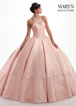 A woman in a pink ball gown posing for a picture at a Quinceañera event