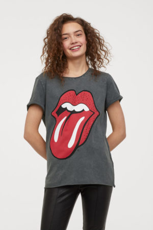 A woman wearing a grey Quinceanera Rolling Stones T-shirt.