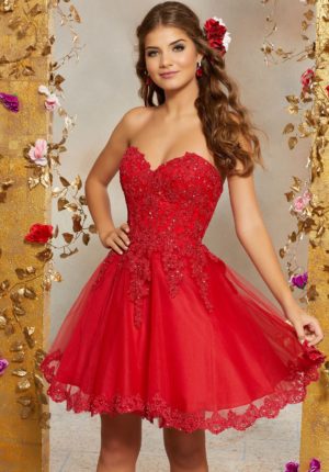 A woman in a red Quinceanera dress posing for a picture