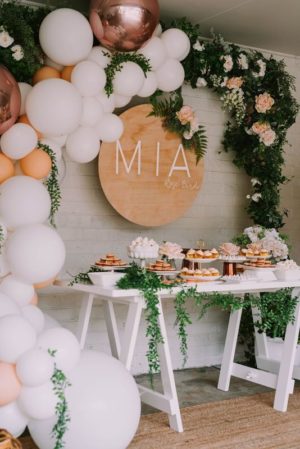 A table topped with lots of white and gold balloons at a Quinceanera party