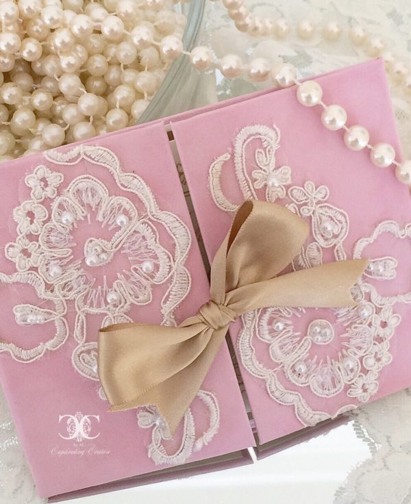A close up of a lilac Quinceanera Invitation, placed on a table with pearls.