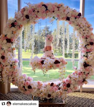 Quinceanera arch decorations with a wedding cake displayed in a floral wreath