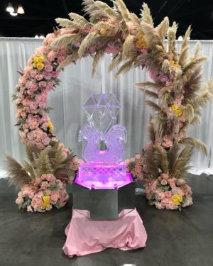 A Quinceañera wedding arch decorated with pink and yellow cut flowers
