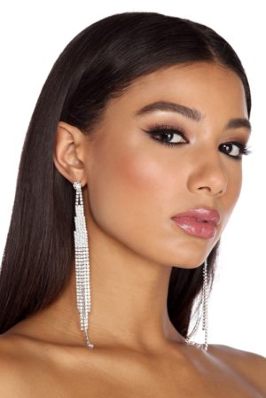 A woman in a strapless Quinceanera dress wearing long earrings