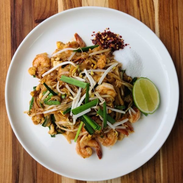 A plate of pad thai Mexican cuisine on a wooden table