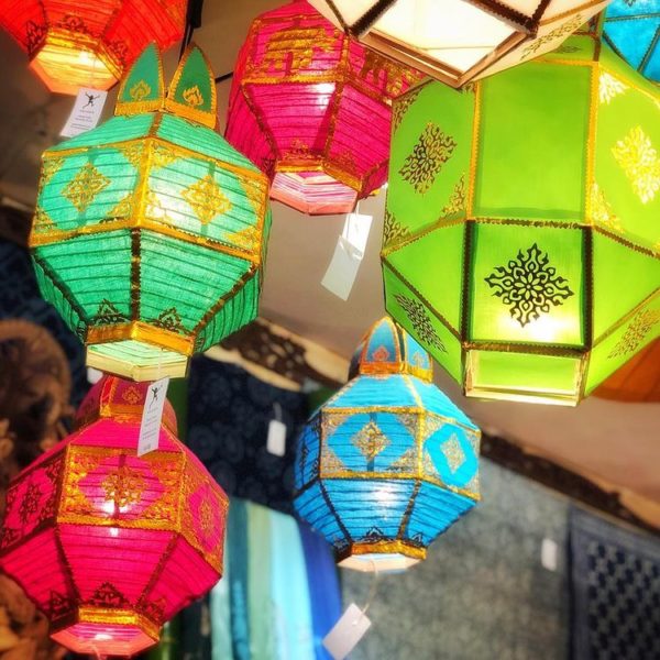 A tradition Lantern with a bunch of colorful paper lanterns hanging from a ceiling at a Quinceanera celebration
