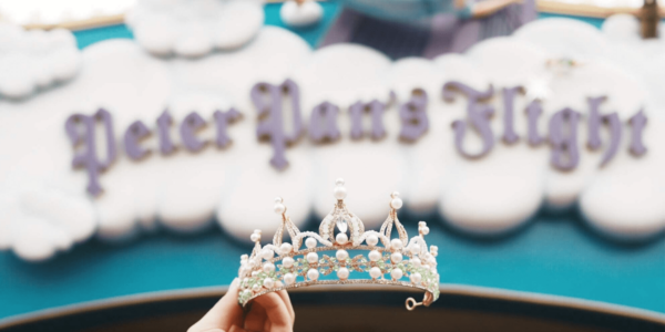 Tinkerbell tiara being held up by a woman's hand