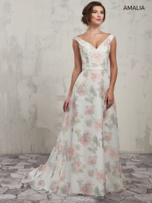 Quinceanera dress, a woman in a floral dress standing in front of a wall