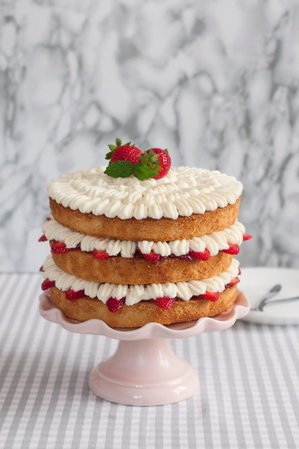 Victorian sponge cake with white frosting and strawberry slices