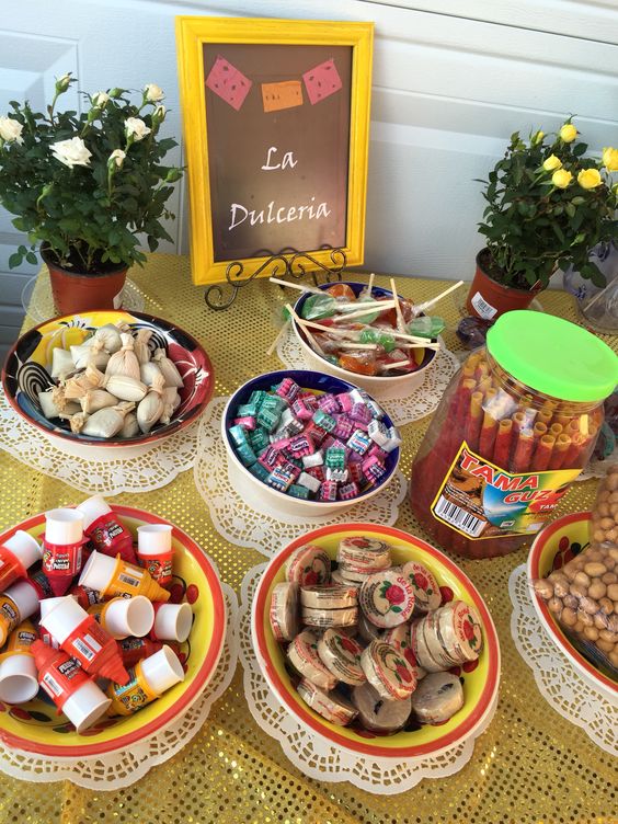 Quinceanera table topped with lots of different types of candies, Mexican cuisine