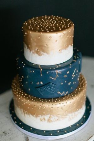 Quinceanera cake, a three-tiered cake with gold and blue decorations, sweet 16 under the stars theme