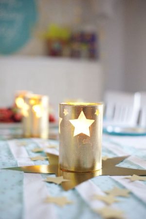 Quinceanera table centros de mesa con estrellas. A table topped with a gold star candle holder.