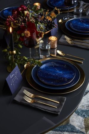 A Quinceanera theme of a night under the stars, featuring The Starry Night painting. The table is set with blue plates and silverware.