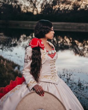 Quinceanera: A woman in a white gown sitting on a drum