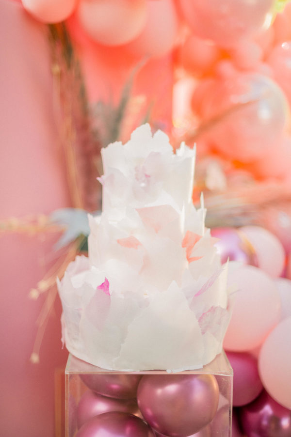 An image of petal Quinceañera dresses displayed in a clear vase filled with pink and white ornaments