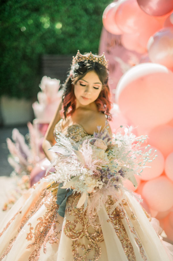 Quinceanera: A woman in a Quinceanera dress holding a bouquet of flowers