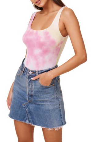 A stylish Quinceanera fashion photo featuring a woman wearing a pink tie dye top and a denim skirt.