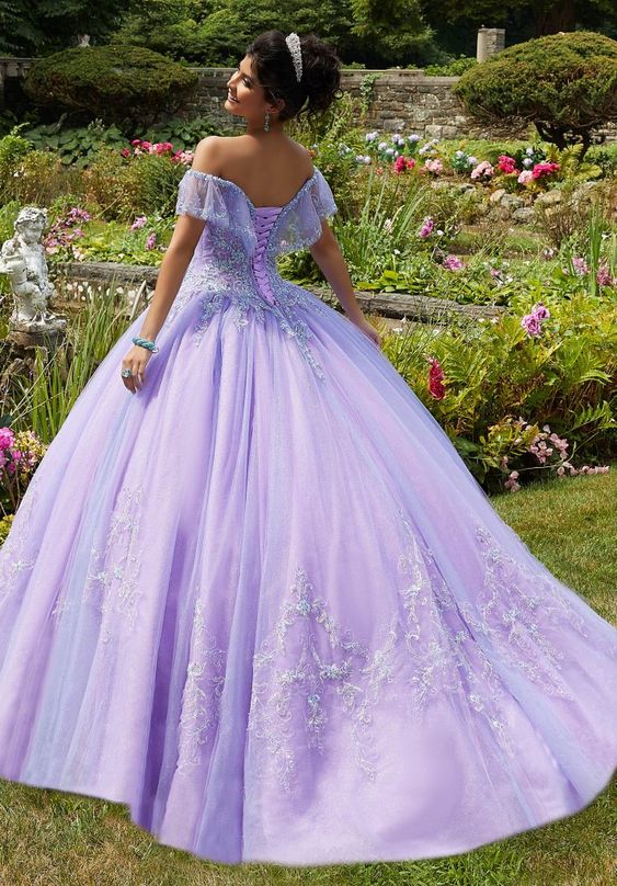 Princess style quinceanera dresses, a woman in a purple ball gown standing in a garden