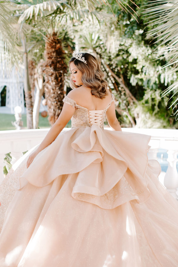 Gown, a woman in a Quinceanera dress standing on a balcony