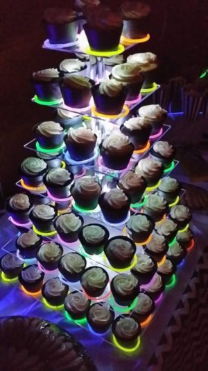 A tower of Quinceanera-themed cupcakes with neon lights on them, used for cake decorating