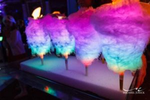 Quinceanera-themed image: A bunch of glow in the dark cotton candy sitting on top of a table