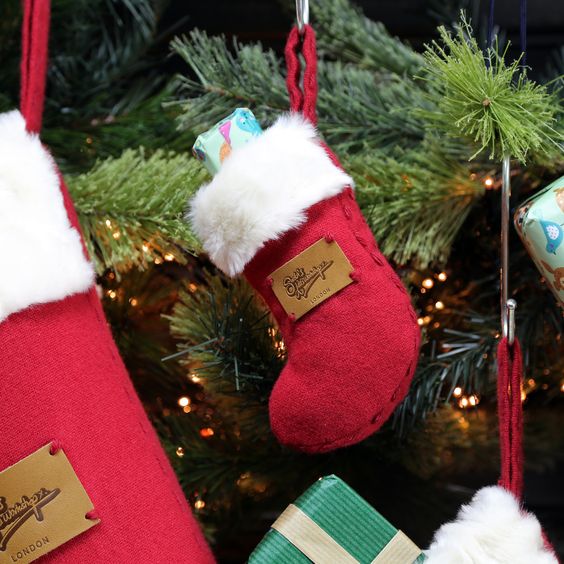 A couple of Christmas stockings hanging from a Christmas tree, decorated with Quinceanera ornaments