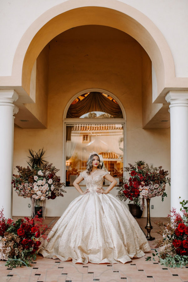 A Quinceanera flower dress displayed on a table with a blue table cloth and silverware