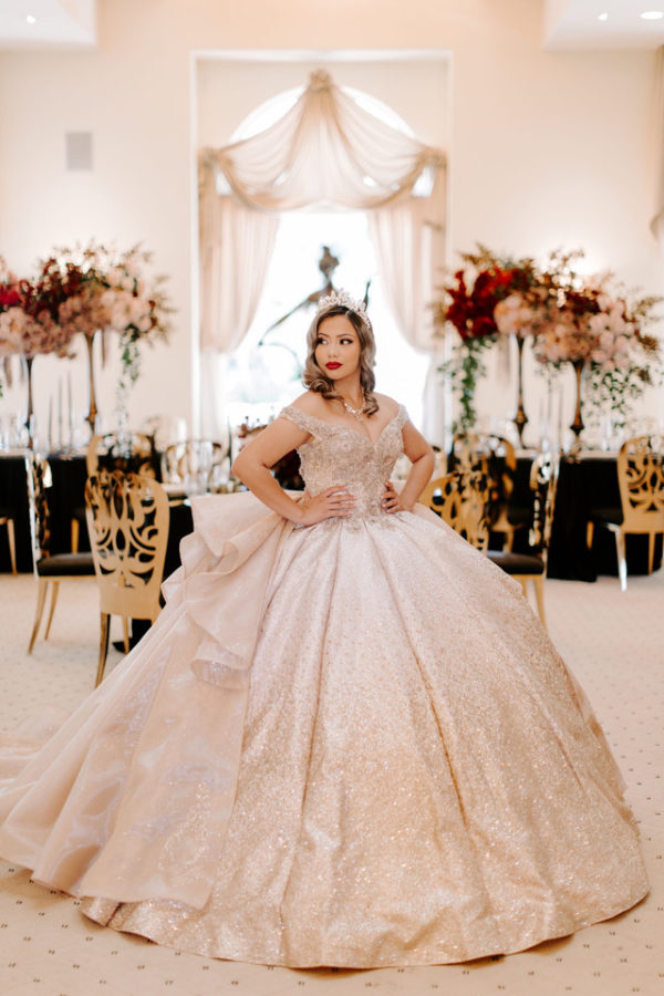 A woman posing for a picture in a Quinceanera gown dress