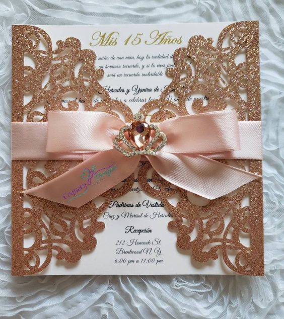 A close up of a Quinceanera rose gold invitation with a bow