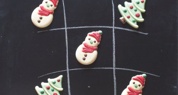 A close up of a snowman on a chalk board with royal icing