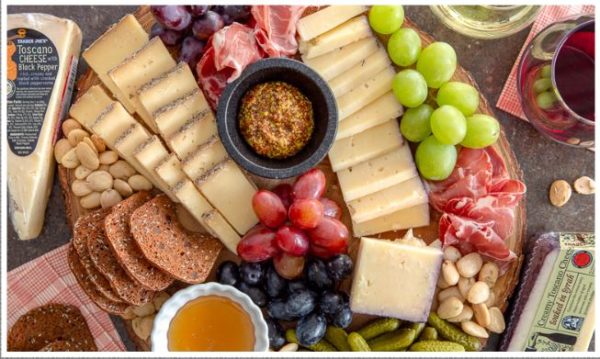 A platter of Gouda cheese, surrounded by a variety of natural foods at a Quinceanera celebration.