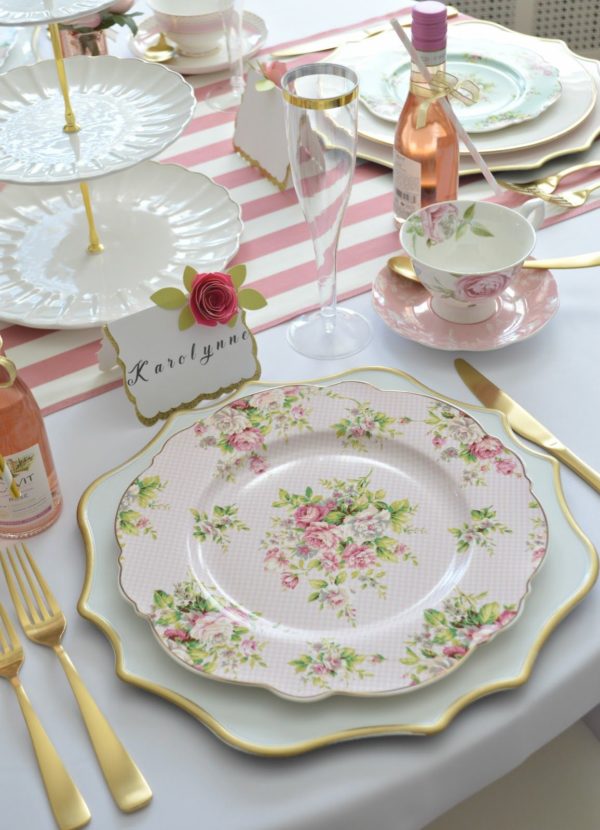 A Quinceanera themed image of a porcelain Plate with a table set for a tea party, adorned with pink roses.