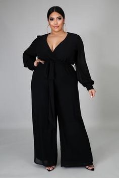 A woman wearing a black jumpsuit and a Quinceanera dress