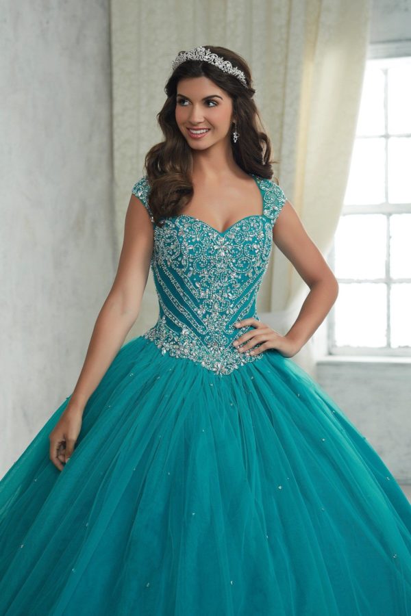Quinceanera: A woman in a blue ball gown posing for a picture