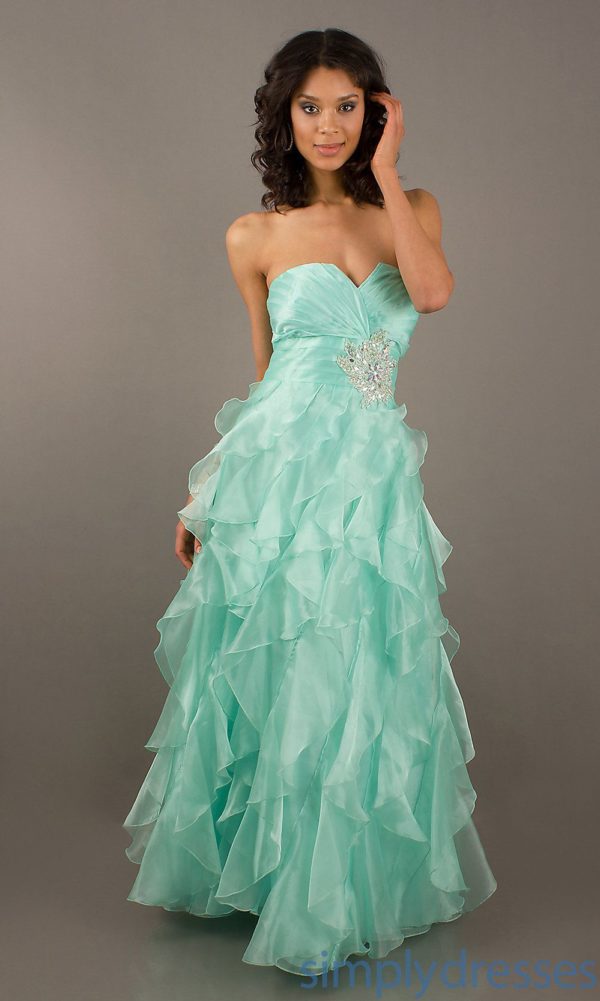 A woman in a green Quinceanera gown posing for a picture
