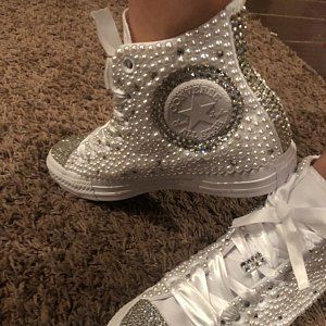 Quinceanera themed image of a pair of white sneakers with rhinestones outdoors