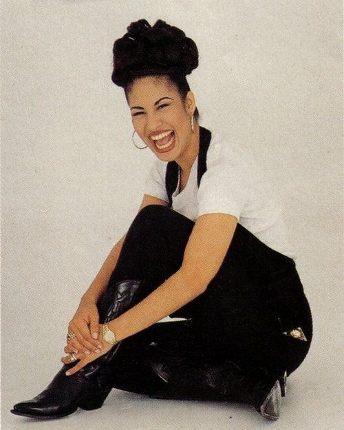 Selena Quintanilla, a woman sitting on the ground with her legs crossed in a Quinceanera themed image