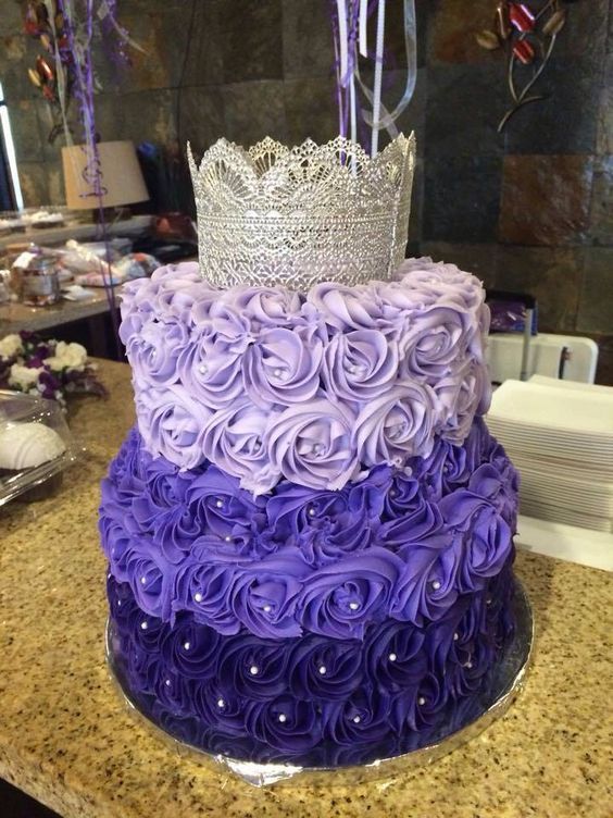 A Quinceanera cake idea featuring a purple and silver design with a crown on top
