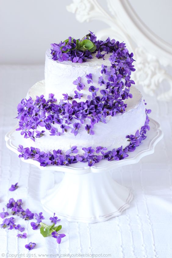 A Quinceanera cake with violets and purple flowers