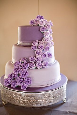 A three-tiered Quinceanera cake with purple flowers on top