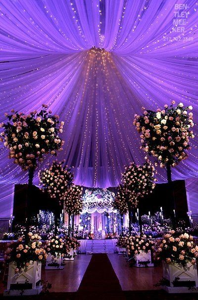Quinceañera with a purple theme, featuring purple drapes and white flowers