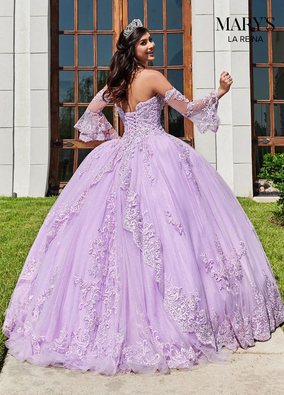 A woman in a lilac Quinceañera dress standing in front of a building